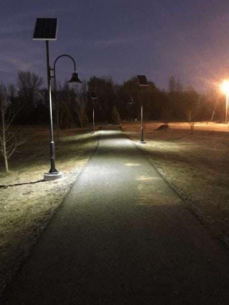 Solar bollard light illuminating a landscaped garden pathway